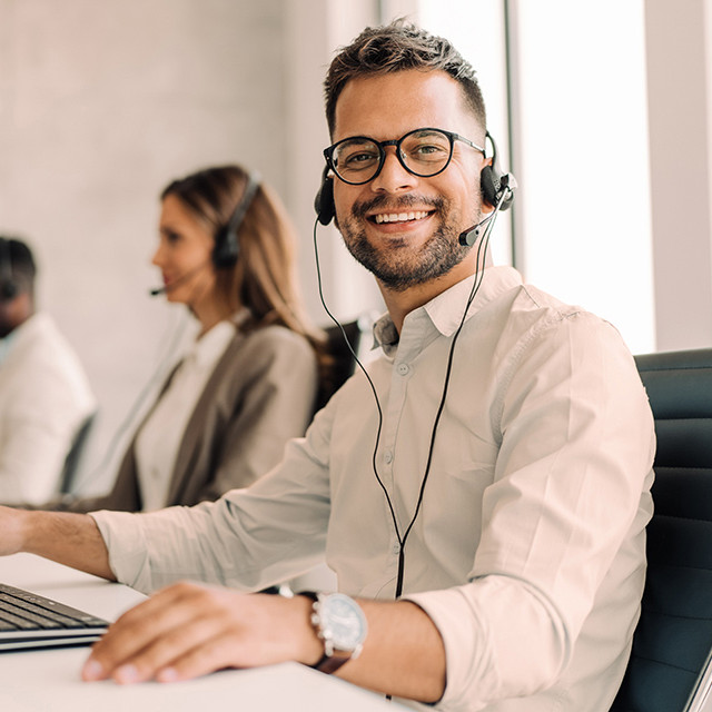 Mitarbeiter mit Headset an einem Schreibtisch